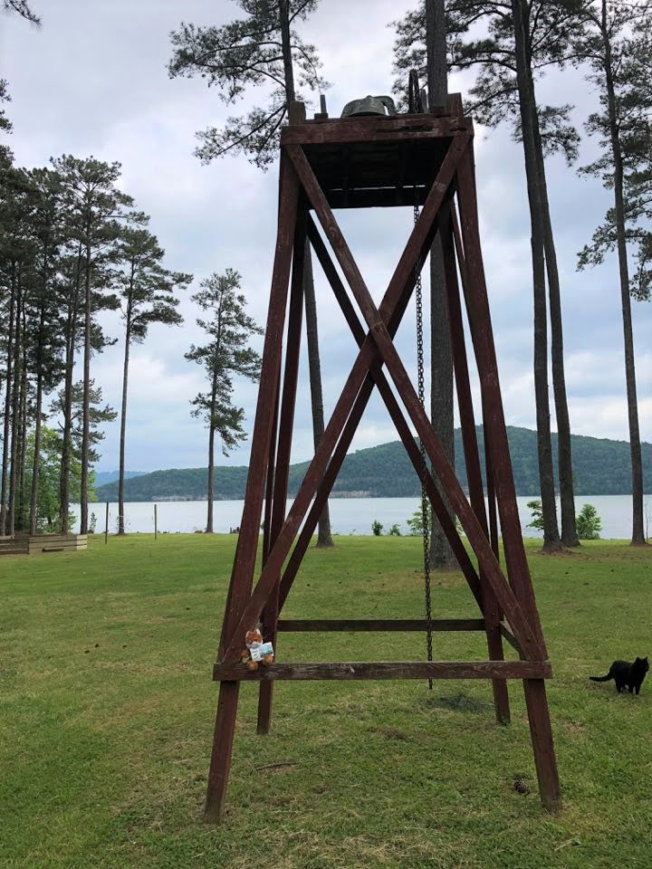 This image captures a large, wooden A-frame structure that houses a bell at the top. The frame appears weathered, suggesting it's been exposed to