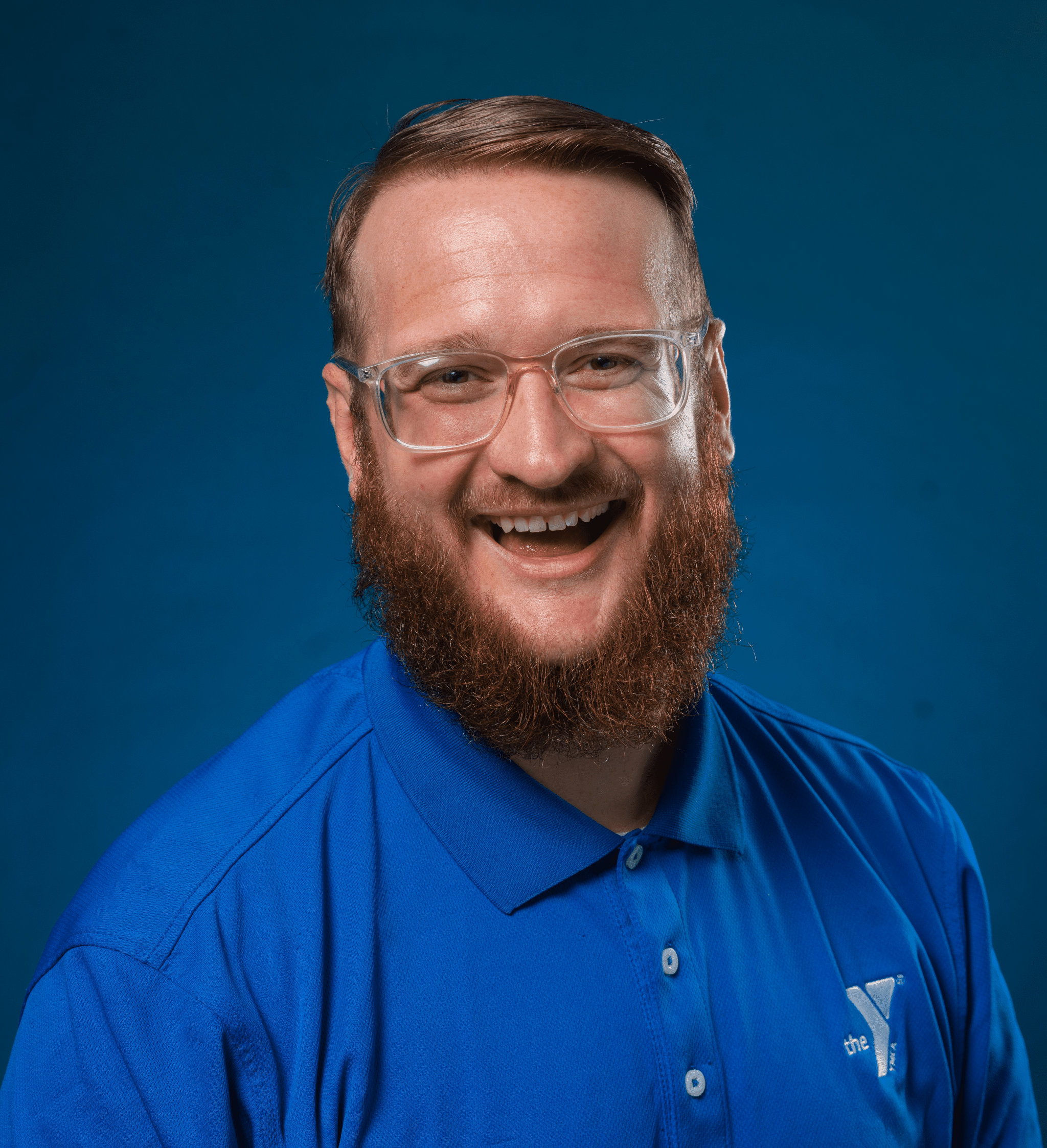 The image features a cheerful man with a prominent red beard, smiling broadly