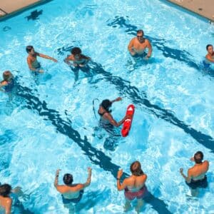 This image is an overhead view of a lively and bright outdoor swimming pool scene during the day.